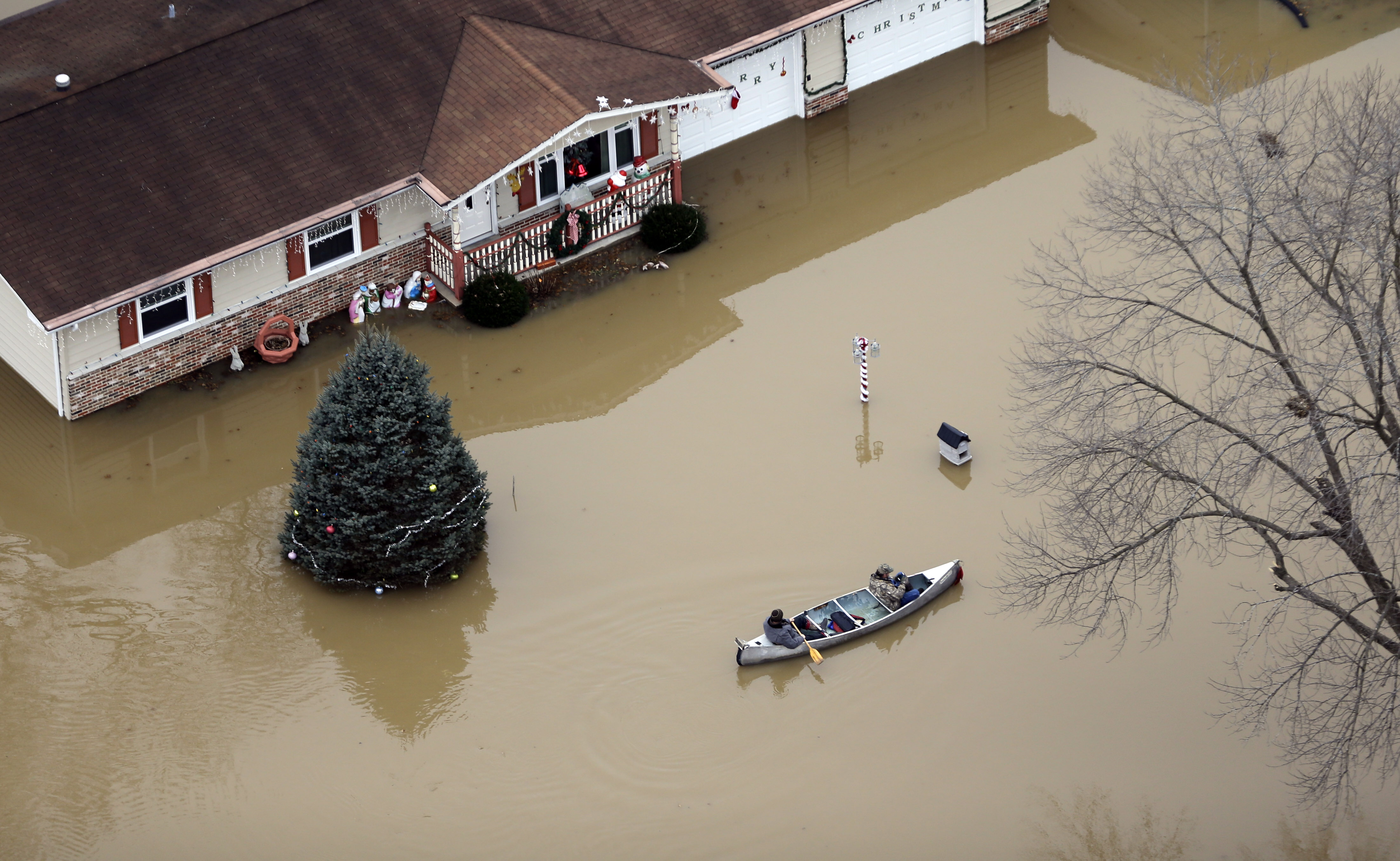 On December 31, 2015, holiday decorations seem out of place on a flooded street in Arnold, MO.