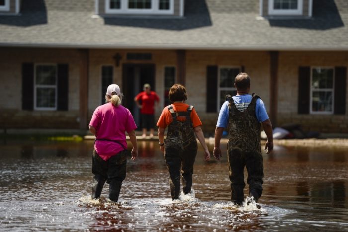 Local Texans walk through a flooded Orange, Texas neighborhood, Sept. 3, 2017. Hurricane Harvey formed in the Gulf of Mexico and made landfall in southeastern Texas, bringing record flooding and destruction to the region. (U.S. Air Force photo by Master Sgt. Joshua L. DeMotts).