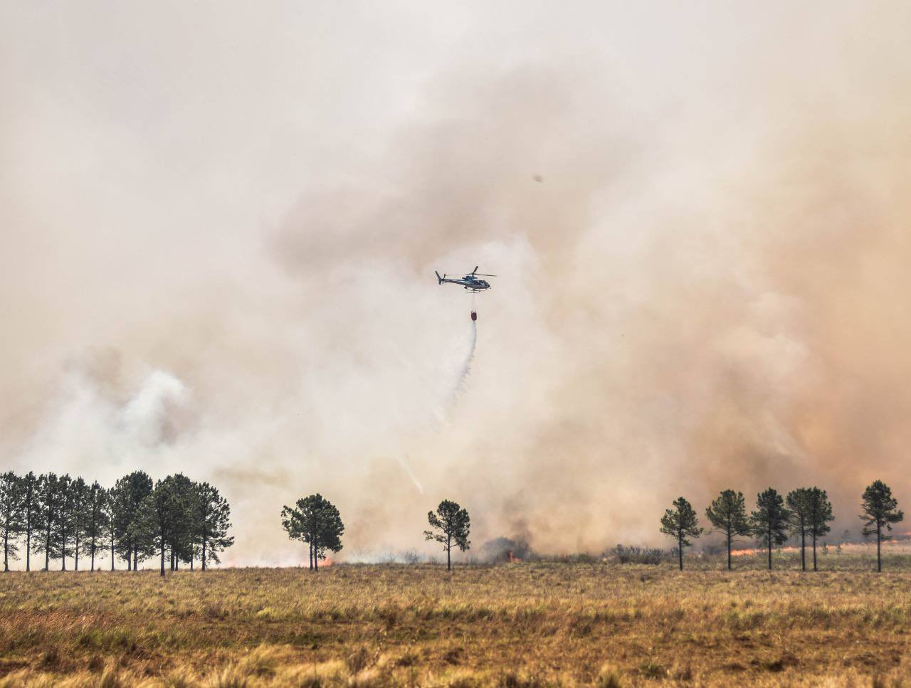 Helicopter flying over fire in a field