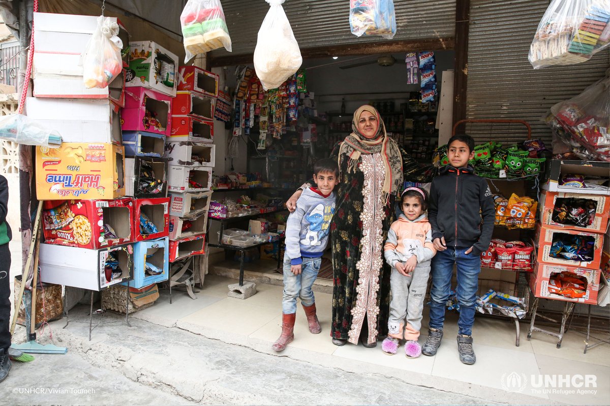 Syrian woman and three children standing in front of a store