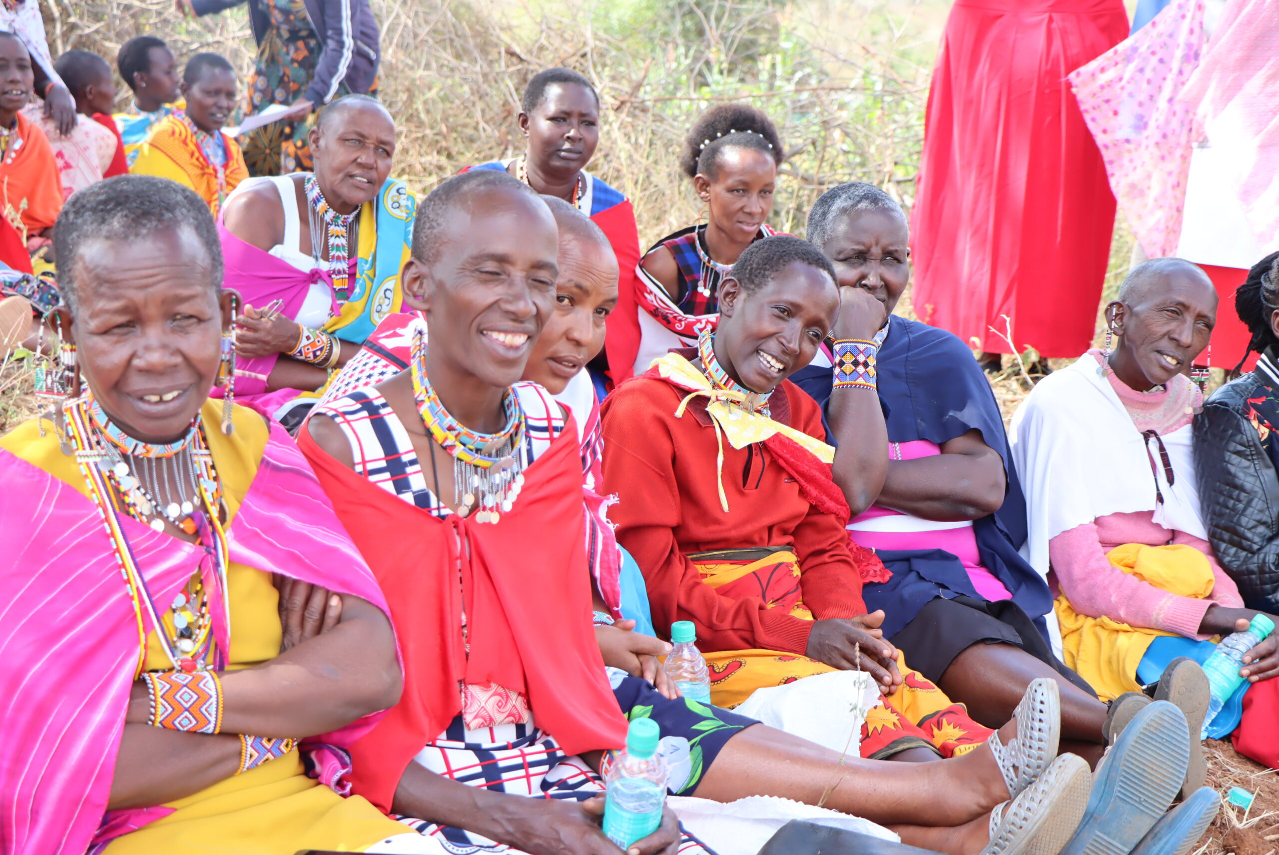 Women sitting on the ground watching a presentation 